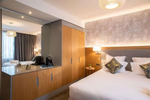 a hotel room with a large bed and a television at Brit Hotel Paris Orly Rungis in Thiais
