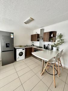 a kitchen with a table and a refrigerator at City Centre Apartment in Windhoek in Windhoek