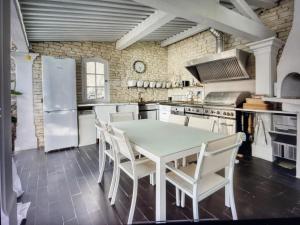 a kitchen with a white table and chairs in it at Maison de 4 chambres avec piscine privee jacuzzi et jardin clos a Aspremont in Aspremont
