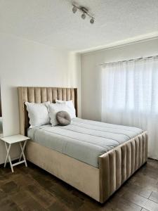 a bedroom with a large bed with a window at City Centre Apartment in Windhoek in Windhoek