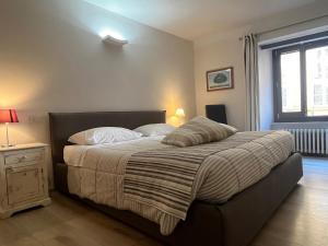 a bedroom with a bed with a striped blanket and a window at Home in Orvieto - Corso Cavour in Orvieto