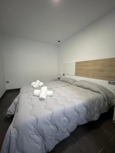ein großes weißes Bett mit Handtüchern darüber in der Unterkunft Apartamento Verdial 2 in La Cala del Moral