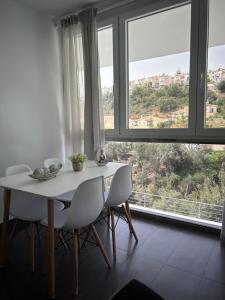 einen weißen Tisch und Stühle in einem Zimmer mit Fenstern in der Unterkunft Apartamento Verdial 2 in La Cala del Moral