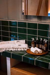 a bathroom counter with several bottles of soap and towels at Casa Akaw in Temalhuacán