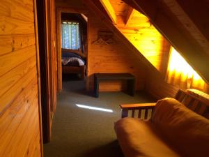 an attic room with a staircase in a wooden cabin at Cabañas La Pampita in Villa La Angostura