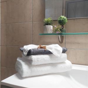 une pile de serviettes assises sur un comptoir dans la salle de bains dans l'établissement Zeusplace Olympous Riviera Villa 1, à Litochoro