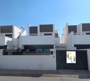 un edificio blanco con un cartel delante en Villa Palmera 2, en San Pedro del Pinatar