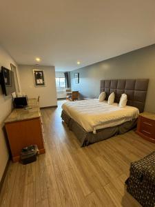 a large bedroom with a large bed and wooden floors at Rodeway Inn Moosic - Scranton in Moosic