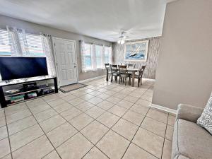 een woonkamer met een televisie en een tafel met stoelen bij Sea Breeze 318 in Gulf Shores