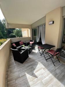 Un patio con sillas y una mesa en el balcón. en Studio coin nuit terrasse parking Clim, en Niza