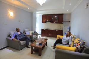 two people sitting on couches in a living room at East Gate Appartement Gust House in Addis Ababa