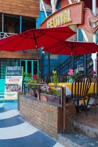 a table and chairs with a red umbrella on a patio at Hotel Festival Plaza Playas Rosarito in Rosarito