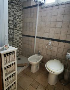 La salle de bains est pourvue de toilettes, d'un lavabo et d'une douche. dans l'établissement La Casa Di Angelo, à Tresnuraghes
