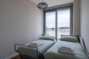 dwa łóżka w pokoju z oknem w obiekcie Luxury Sempione - Monumentale [Duomo-Cenisio] w Mediolanie