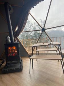 a fireplace in a tent with two beds and a table at Bogina Dome & Suite - Çamlıhemşin in Çamlıhemşin