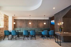 uma sala de jantar com cadeiras azuis e um bar em Bizarre Boutique Hotel em Varna City