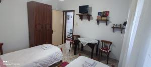 a bedroom with a bed and a table and chairs at Guest House Baba Lluka in Berat