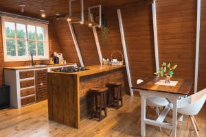 a kitchen with wooden walls and a wooden counter top at Refúgio Fortaleza - Cabana Amora in Cambará