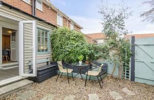 a patio with a table and chairs in front of a house at Turnstone Retreat - Parking in Sheringham