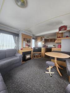 a living room with a couch and a table at Kingfisher OAK 1098 Dees Caravan Lettings in Ingoldmells +11 photos