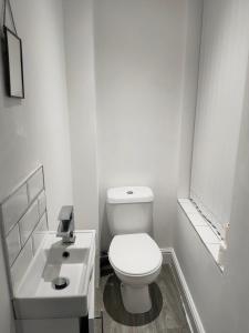a white bathroom with a toilet and a sink at Beautiful Single Bedroom in Liverpool