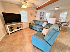 uma sala de estar com um sofá azul e uma televisão de ecrã plano em Porpoise Pass em Foley