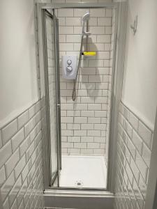 a shower in a bathroom with white tiles at Beautiful Single Bedroom in Liverpool