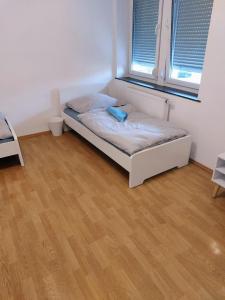 L8 Street - Leipziger Straße في كايزرسلاوترن: سرير صغير في غرفة مع أرضية خشبية