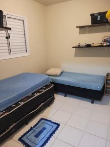 a room with two beds and a rug on the floor at Casa com piscina aconchegante in Ribeirão Preto