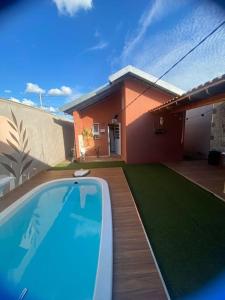 a house with a swimming pool in front of a house at Casa com piscina aconchegante in Ribeirão Preto