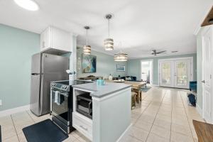a kitchen with a stainless steel refrigerator and a table at 2 BR Home in St Andrews, Close to Everything in Panama City