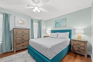 a bedroom with a blue bed and a ceiling fan at 2 BR Home in St Andrews, Close to Everything in Panama City