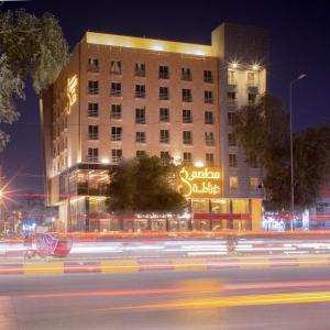 a building with a sign on the side of it at night at Granada Hotel in An Najaf