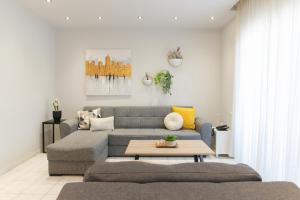 un soggiorno con divano e tavolo di Magico Home City Heart Luxury Appartment a Alexandroupoli