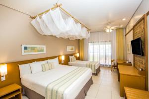 a hotel room with two beds and a television at Blue Tree Thermas de Lins Resort in Lins