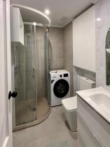 łazienka z prysznicem i pralką w obiekcie CASA BLANCA w mieście Torrevieja