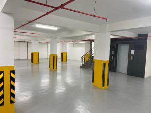 a large empty room with yellow columns and a staircase at Neema Executive Suites Near Junction Mall With Balcony in Nairobi