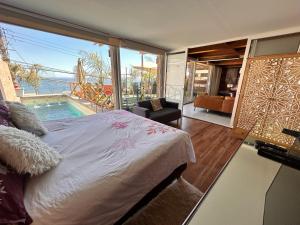 a bedroom with a bed and a view of a pool at Pacificsunset Reñaca in Viña del Mar