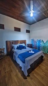 a bedroom with a bed with a blue comforter and a ceiling at Hostel Recanto da Sereia in Salvador
