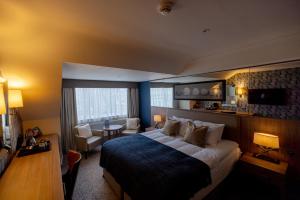 um quarto de hotel com uma cama grande e uma sala de estar em Brisbane House Hotel em Largs