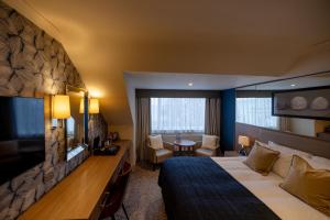 a hotel room with a large bed and a desk at Brisbane House Hotel in Largs
