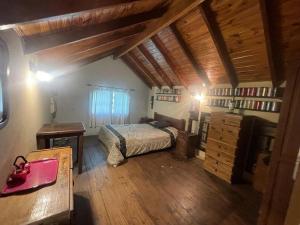 ein Schlafzimmer mit einem Bett und einer Kommode im Dachgeschoss in der Unterkunft Casa Leloir in Villa Leloir