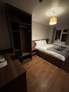 una piccola camera con letto e specchio di The Watling Inn a Nuneaton