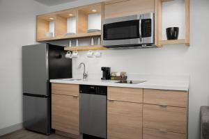 eine Küche mit einem schwarzen Kühlschrank und einer Mikrowelle in der Unterkunft TownePlace Suites by Marriott Birmingham South in Birmingham