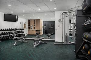 Habitación con gimnasio con sillas y TV. en TownePlace Suites by Marriott Birmingham South, en Birmingham