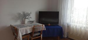 a table with a television and a blue table cloth at Pokój blisko centrum in Bielsko-Biała