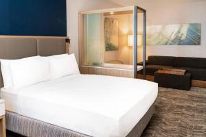 een slaapkamer met een groot wit bed en een bank bij SpringHill Suites by Marriott Irvine Lake Forest in Lake Forest