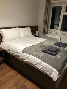 een bed met twee handdoeken in een slaapkamer bij The Watling Inn in Nuneaton