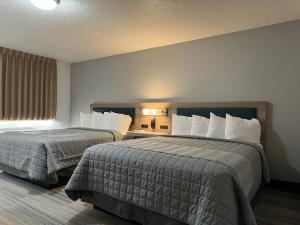 Una habitación de hotel con dos camas y una ventana. en Bearcat Inn and Suites, en Maryville
