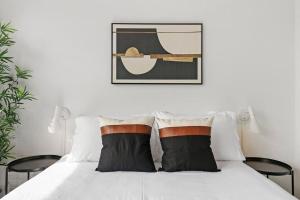 uma cama branca com duas almofadas pretas e brancas em Warm & Elegant Studio Apt in Chicago - Algonquin 06-005A rep em Chicago